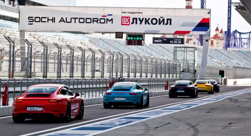 Вереница
Porsche 911
с журналистами
за рулем
на гоночной трассе - фото